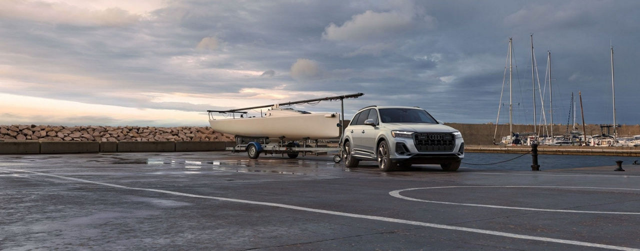 A white 2025 Audi Q7 for sale towing a boat.